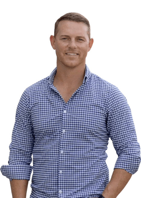 Greg Harris, Realtor, standing and smiling in a blue checked shirt